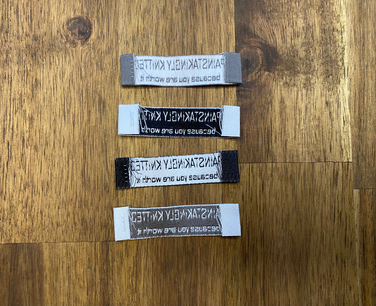 "Painstakingly knitted. Because you are worth it." - Clothing Labels for Knitted Garments - 15 mm height, 60 mm length. 4 pcs. Cotton. Black, white and gray.