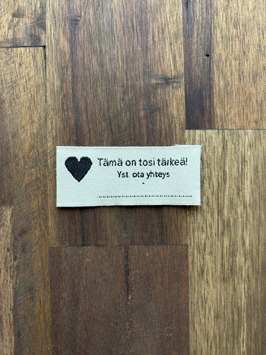 "Tämä on tosi tärkeä! Yst. ota yhteys" Sew-in tag with contact info for clothing, accessories and toys