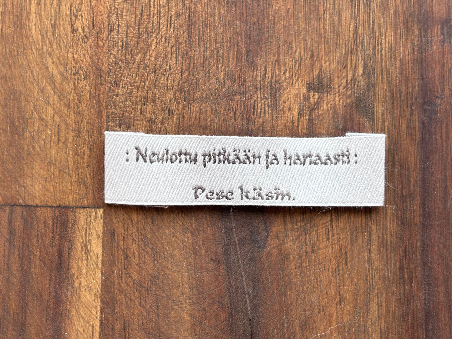 "Neulottu pitkään ja hartaasti. Pese käsin." - Clothing Labels for Knitted Garments - 15 mm height, 60 mm length. 8 pcs. Cotton. Black, white and gray.