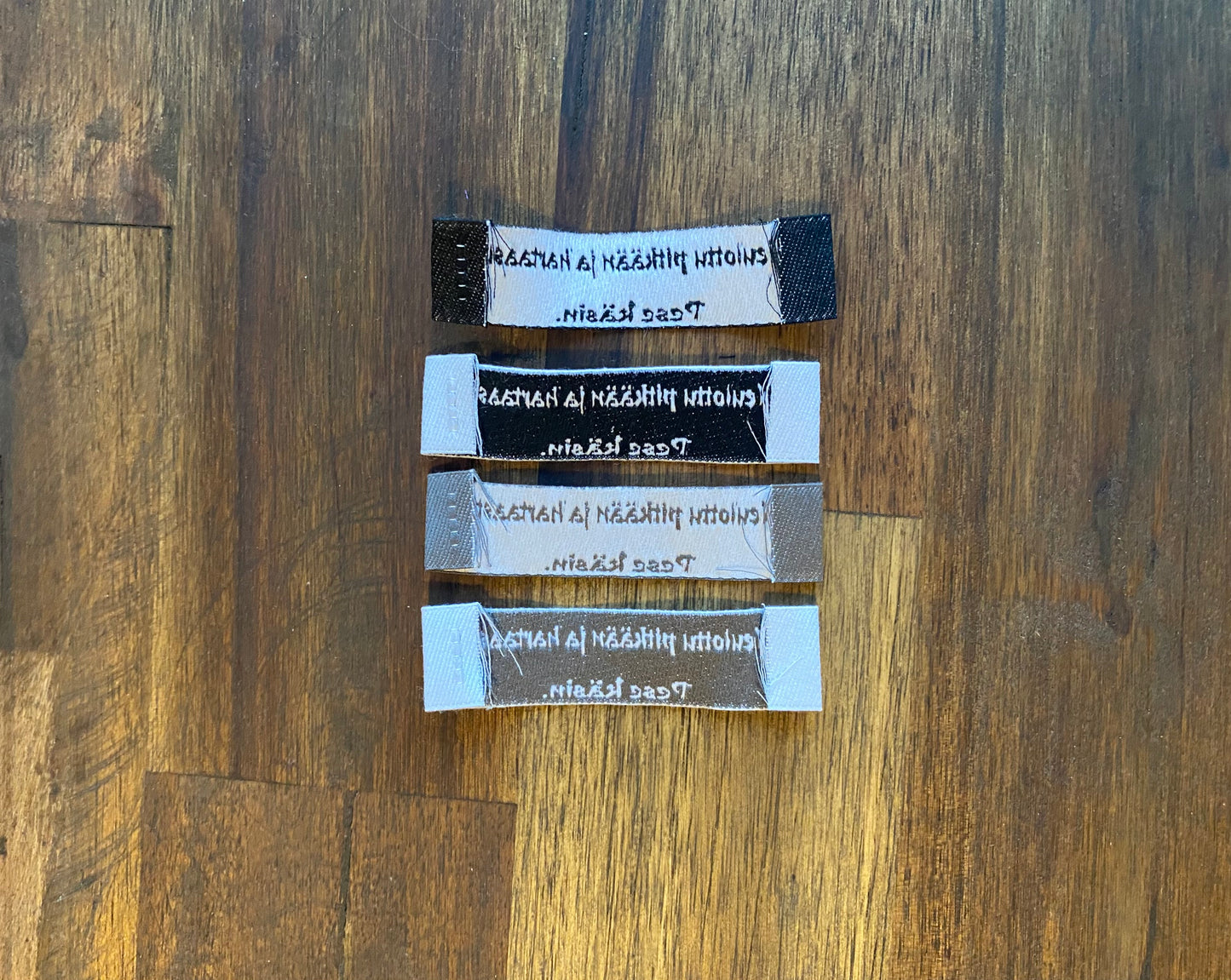 "Neulottu pitkään ja hartaasti. Pese käsin." - Clothing Labels for Knitted Garments - 15 mm height, 60 mm length. 4 pcs. Black, grey, white..