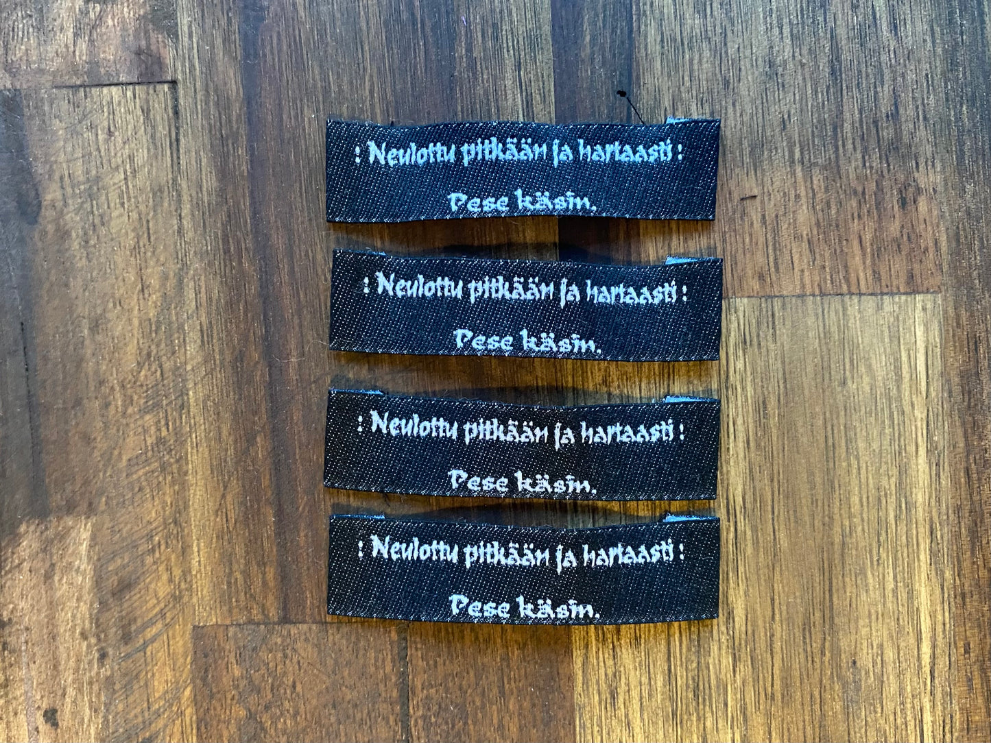"Neulottu pitkään ja hartaasti. Pese käsin." - Clothing Labels for Knitted Garments - 15 mm height, 60 mm length. 4 pcs. Black, grey, white..