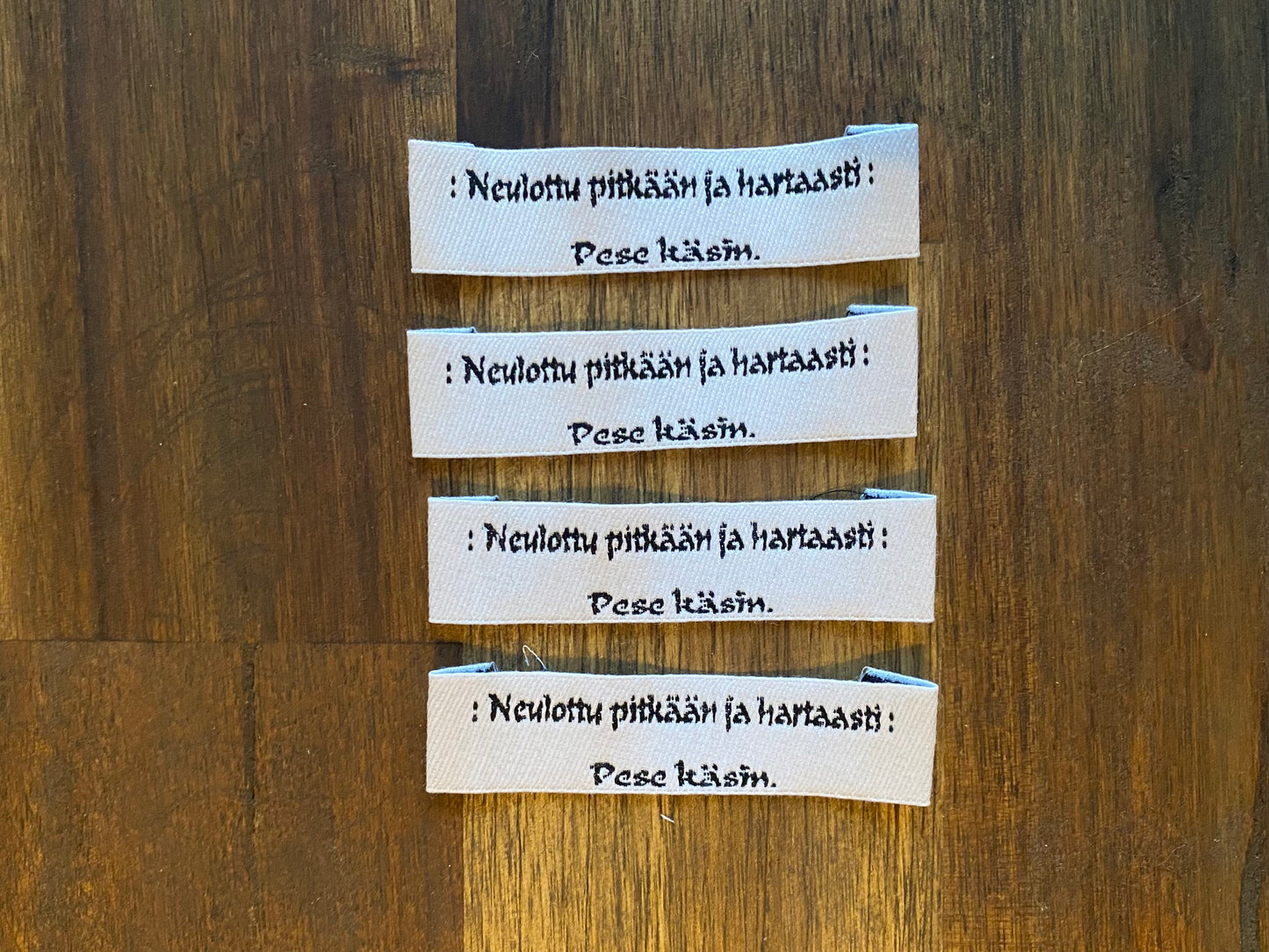 "Neulottu pitkään ja hartaasti. Pese käsin." - Clothing Labels for Knitted Garments - 15 mm height, 60 mm length. 4 pcs. Black, grey, white..