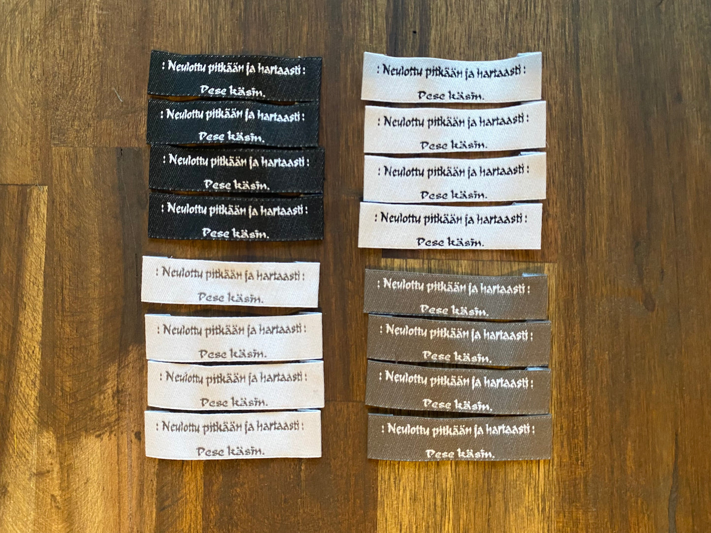 "Neulottu pitkään ja hartaasti. Pese käsin." - Clothing Labels for Knitted Garments - 15 mm height, 60 mm length. 4 pcs. Black, grey, white..